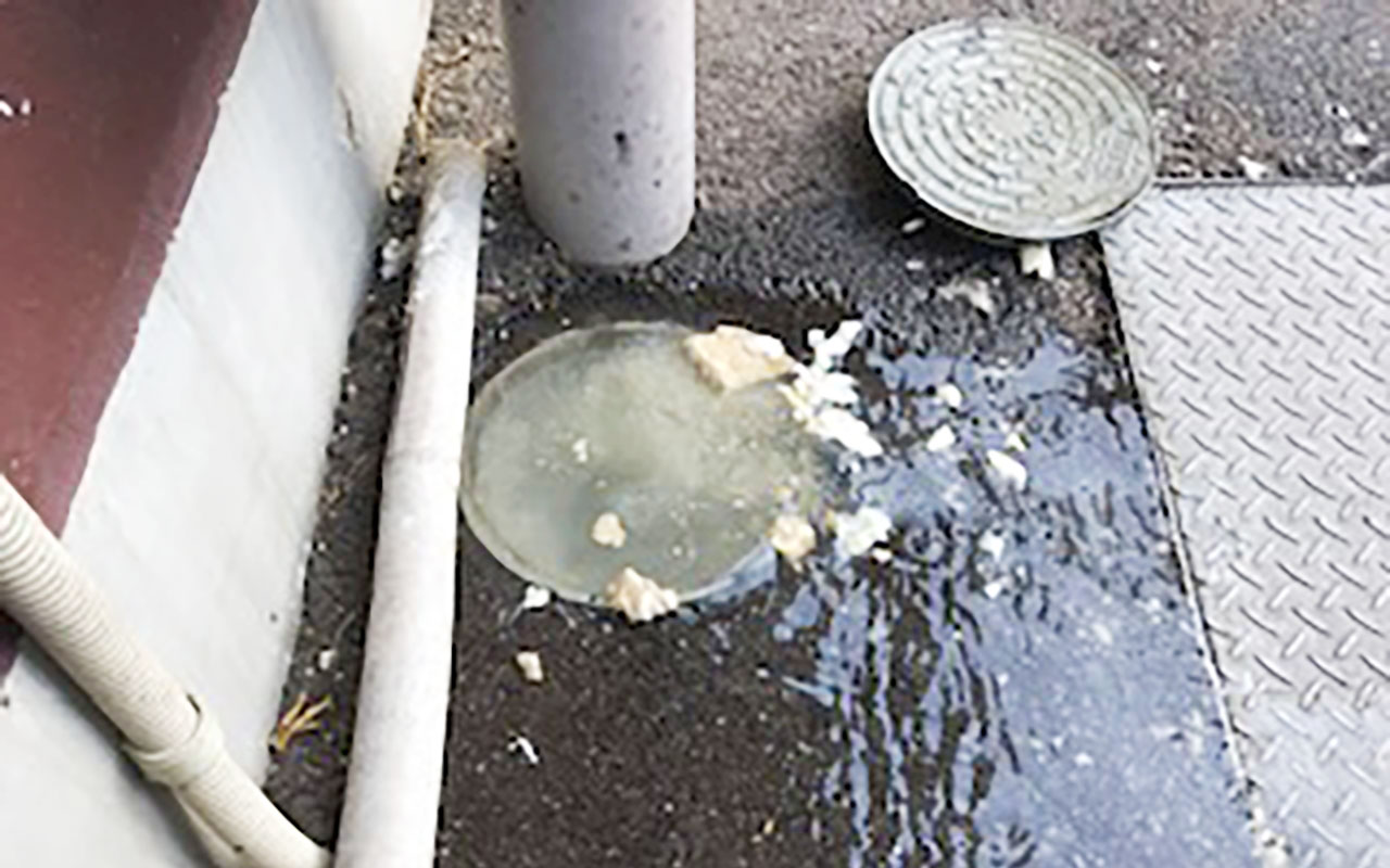 排水管が詰まって汚水枡から水があふれ出している状況